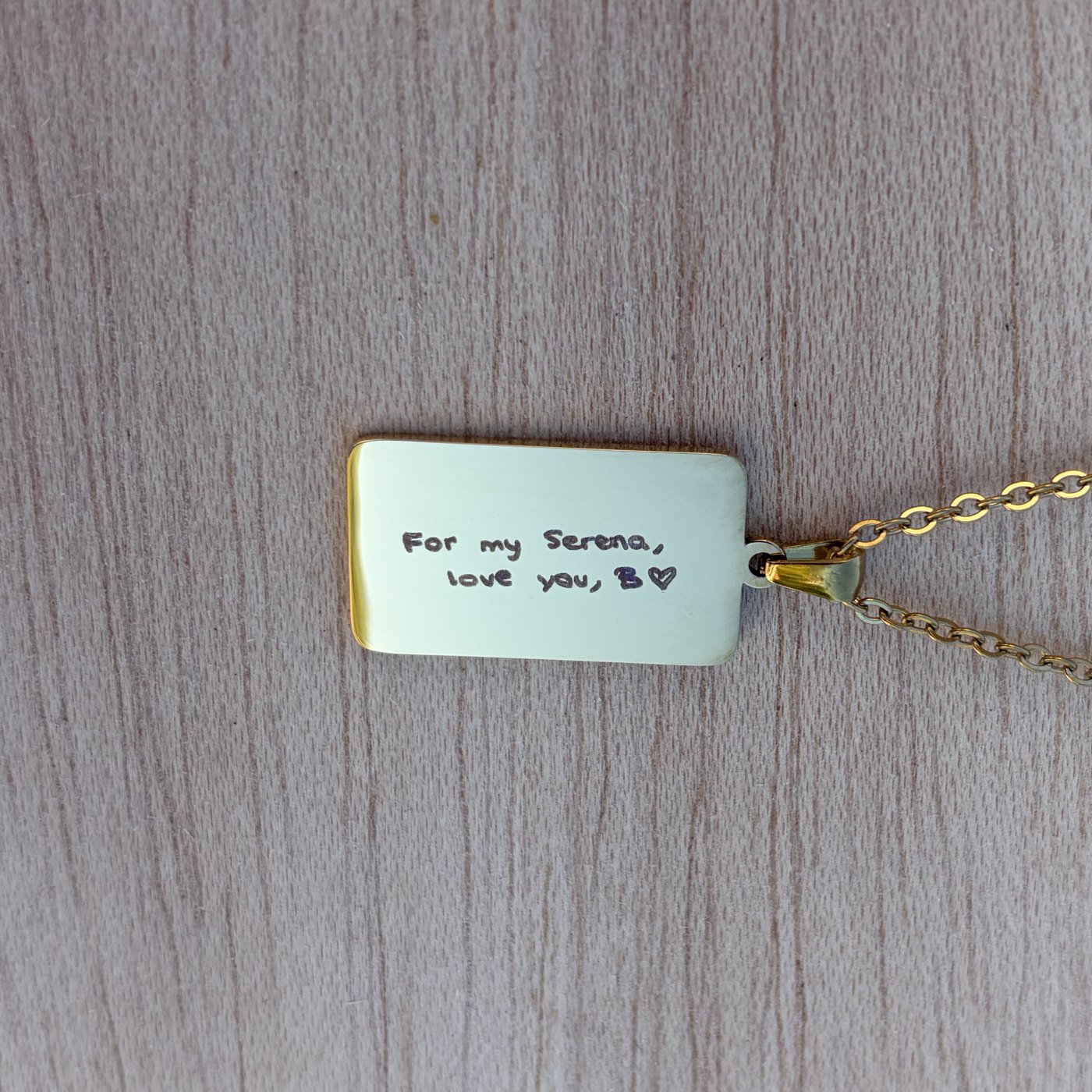 Colgante rectangular con baño de oro grabado a láser con una frase escrita a mano: For my Serena, love you, B