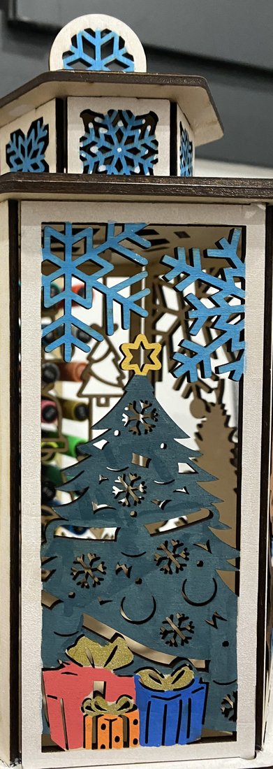 Fanalet de madera calado con copos de nieve azules, abeto de Navidad y regalos